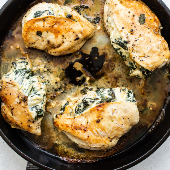 Chicken breasts with spinach in a skillet.