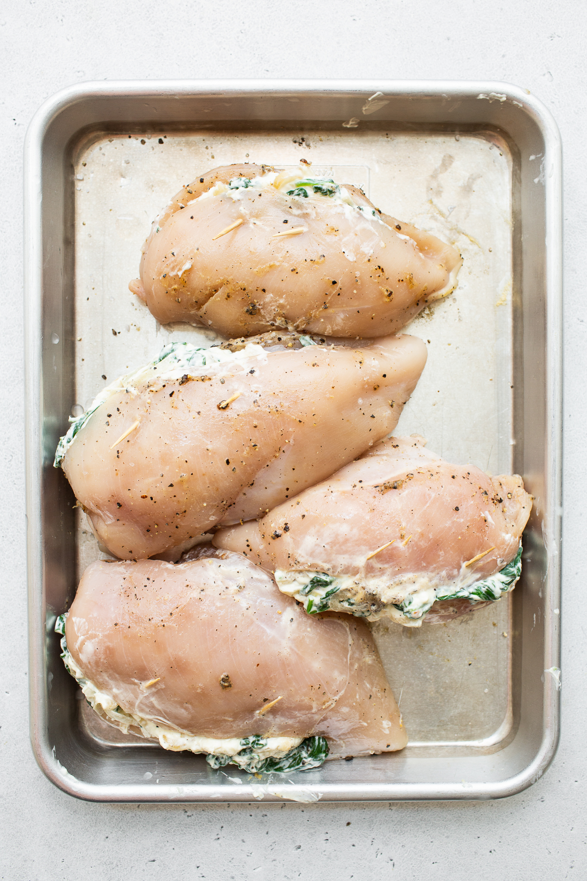 Stuffed chicken breast on a baking sheet.