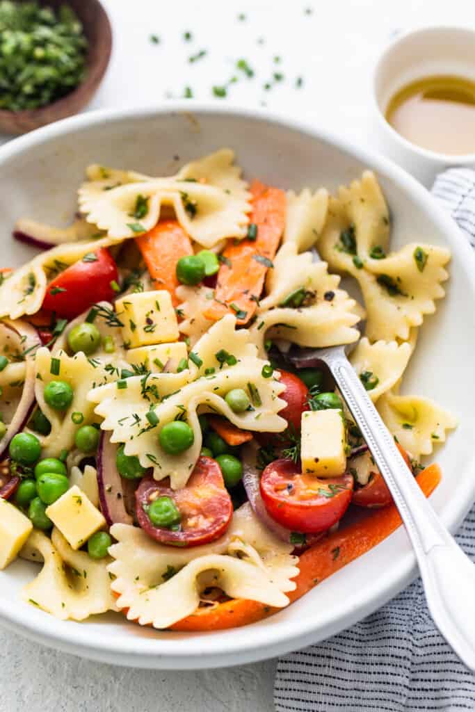 Bow tie pasta salad in a bowl with a fork.