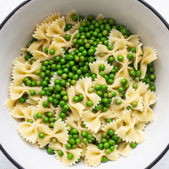 A bowl of pasta with peas in it.