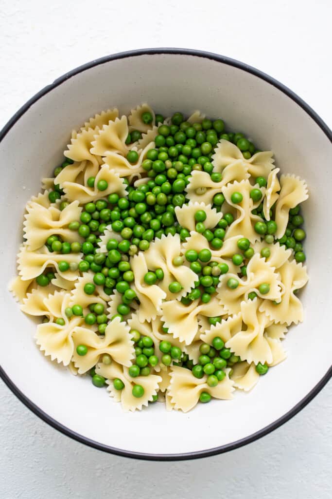 Bow tie pasta and peas in a bowl.