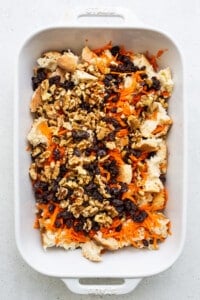 A white baking dish filled with carrots and nuts.
