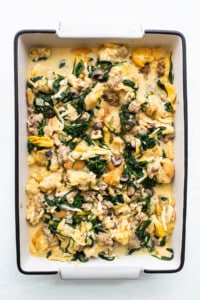 A casserole dish filled with spinach and mushrooms.