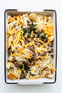 A casserole dish filled with meat, cheese and spinach.