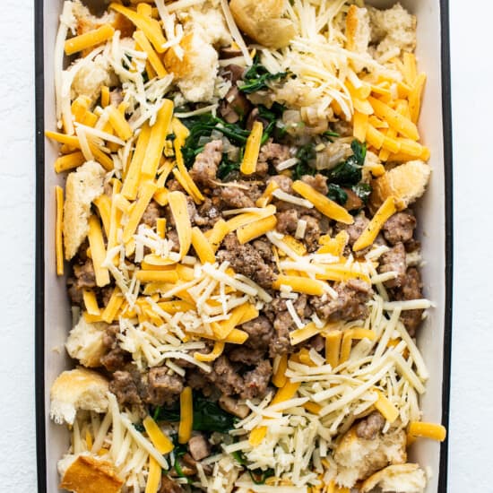 A casserole dish filled with meat, cheese and spinach.