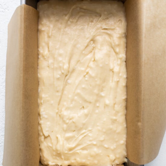 A cake in a baking pan on a white surface.