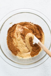 Adding cinnamon to the cake batter.