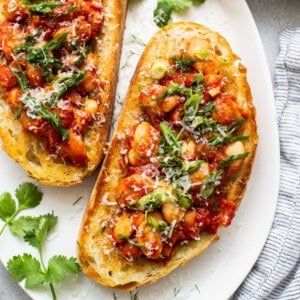 Chickpea and tomato bruschetta on a white plate.