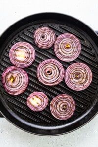 Red onion rings on a grill.