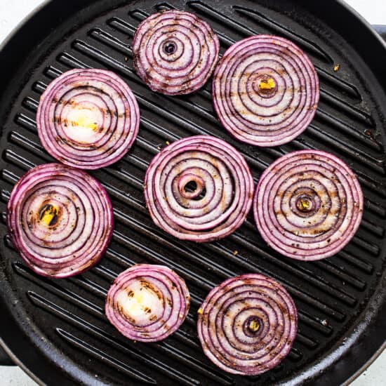Red onion rings on a grill.