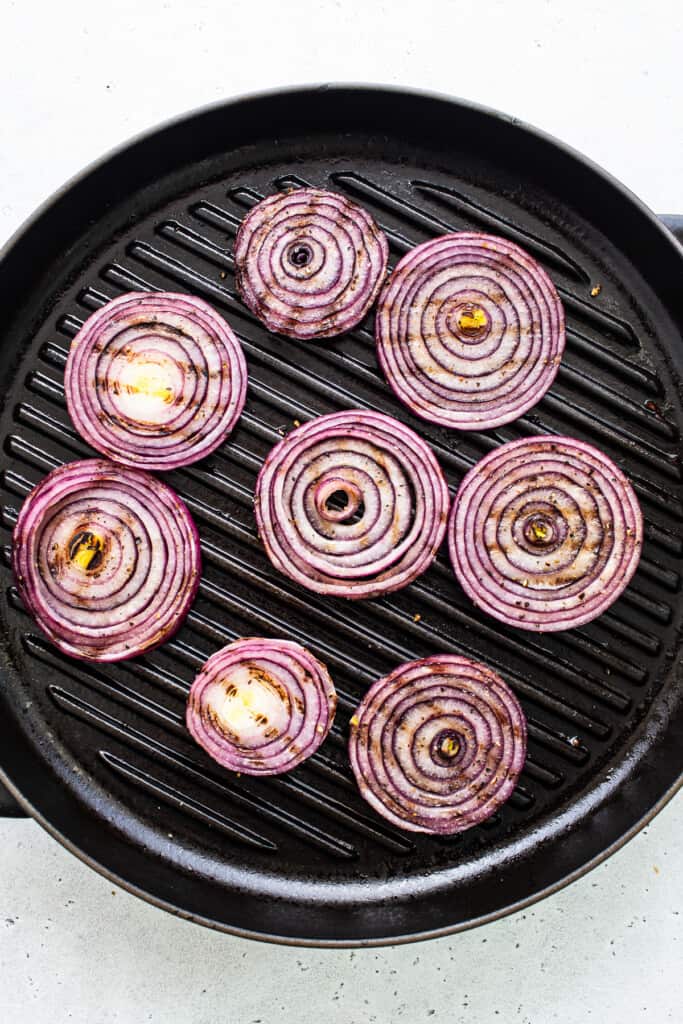 Red onions in a grill pan.