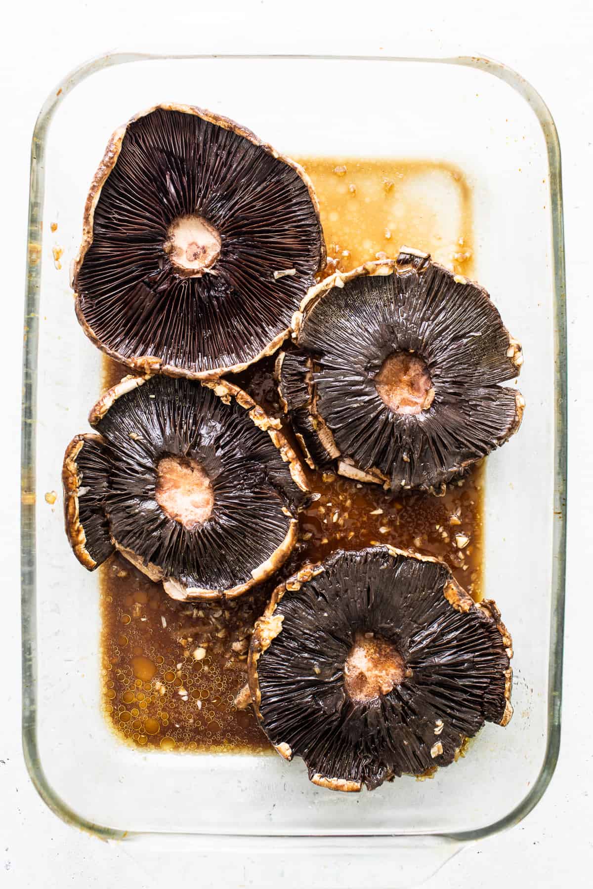 Portobello mushrooms in a marinade.