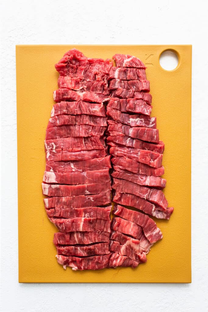 sliced flank steak on cutting board.