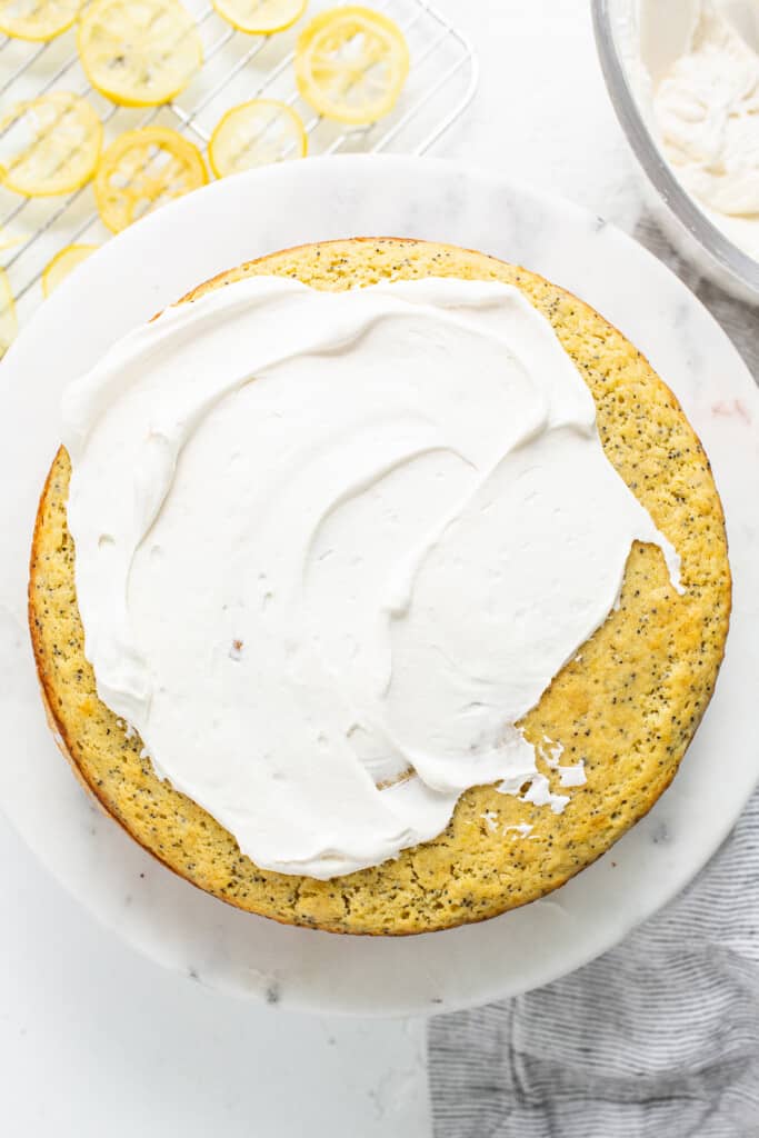 Lemon poppy seed cake topped with whipped cream icing.