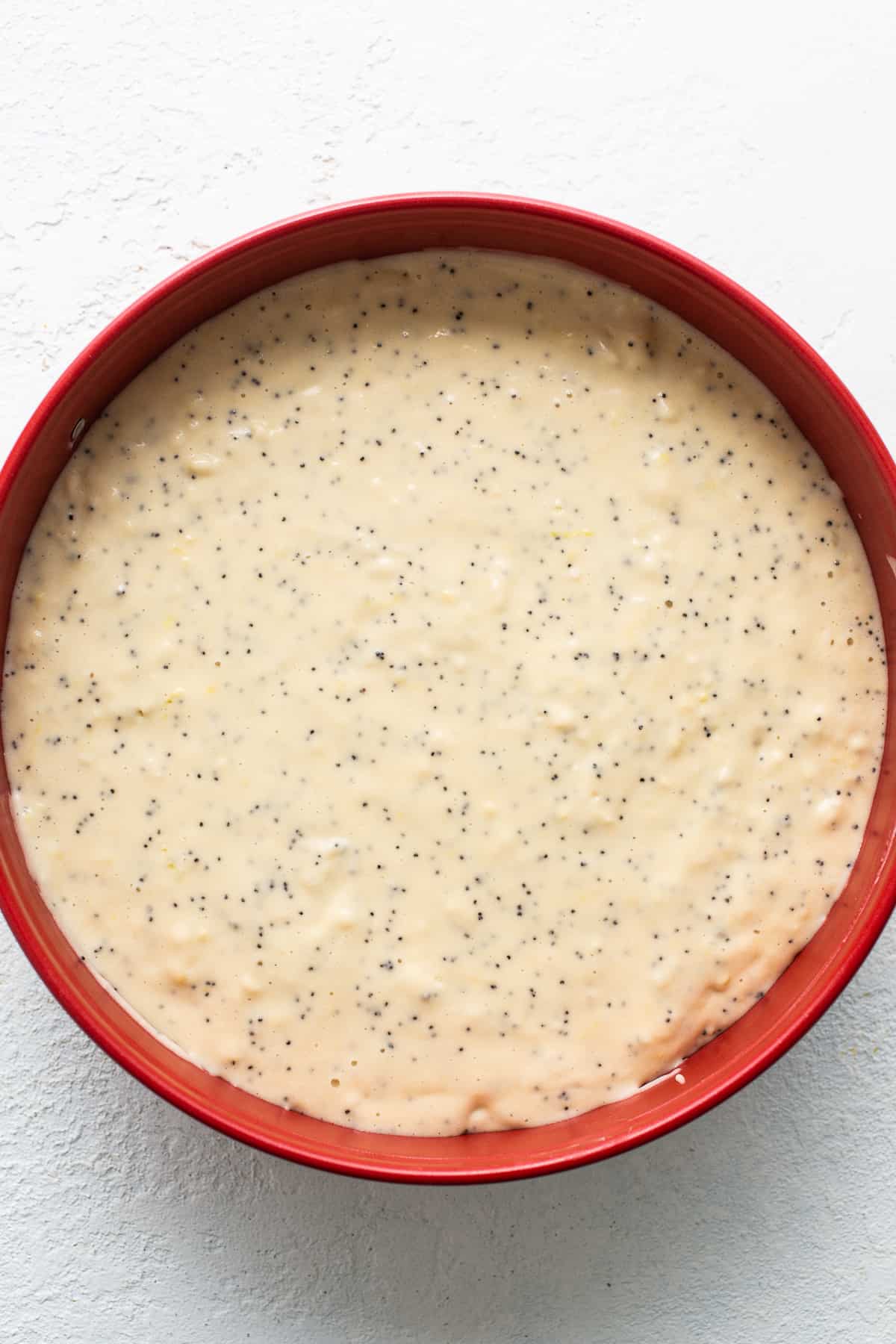 Lemon poppy seed cake batter in a cake pan.