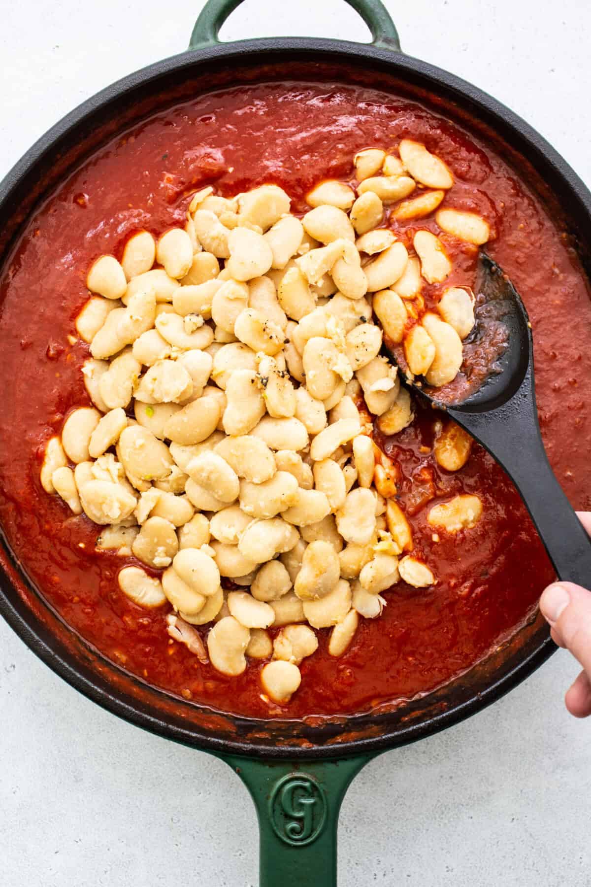 A skillet filled with beans and sauce.