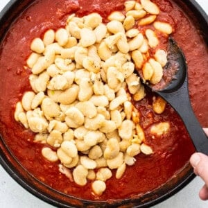 A skillet filled with beans and sauce.