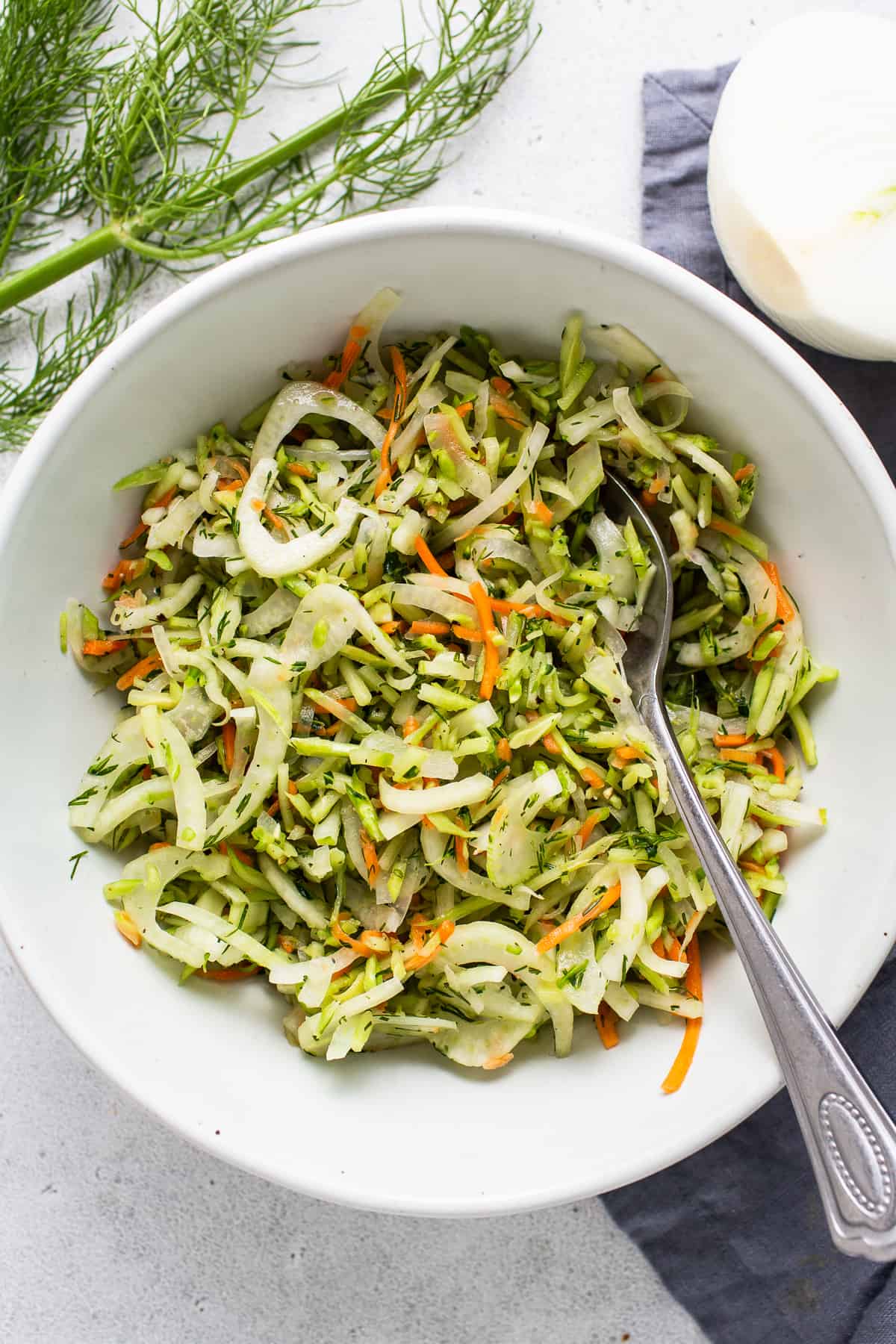 A bowl of dill slaw with carrots and onions.