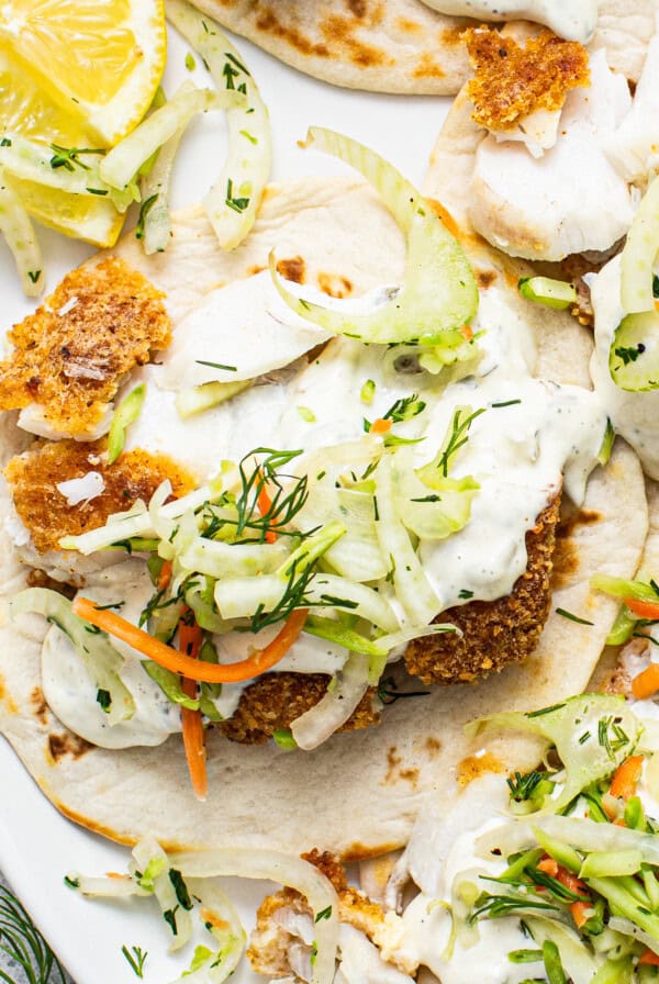 Fish tacos with slaw and lemon wedges.