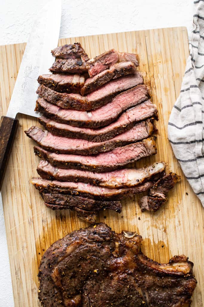 Sliced air fryer steak on a cutting board.