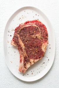 A piece of steak on a white plate.