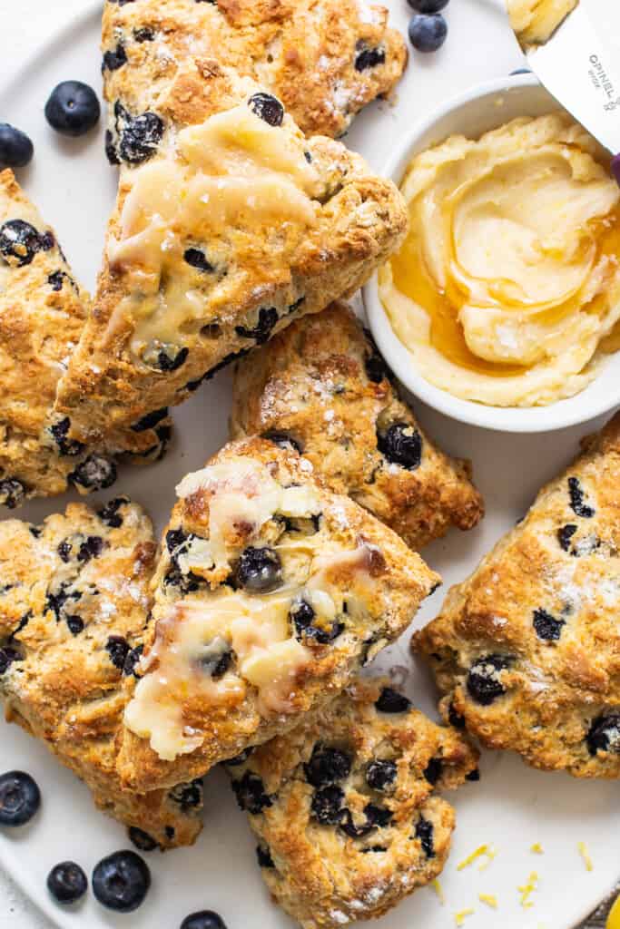 a white plate topped with scones and blueberries.