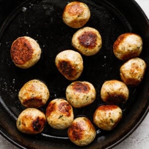 pan frying meatballs in pan.