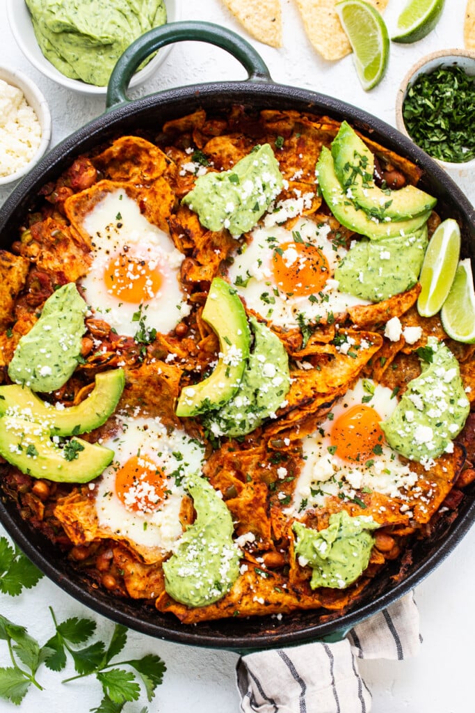 chilaquiles with avocado crema in cast iron skillet.