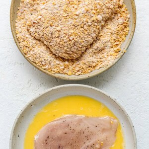dredging chicken in egg and cornflakes.