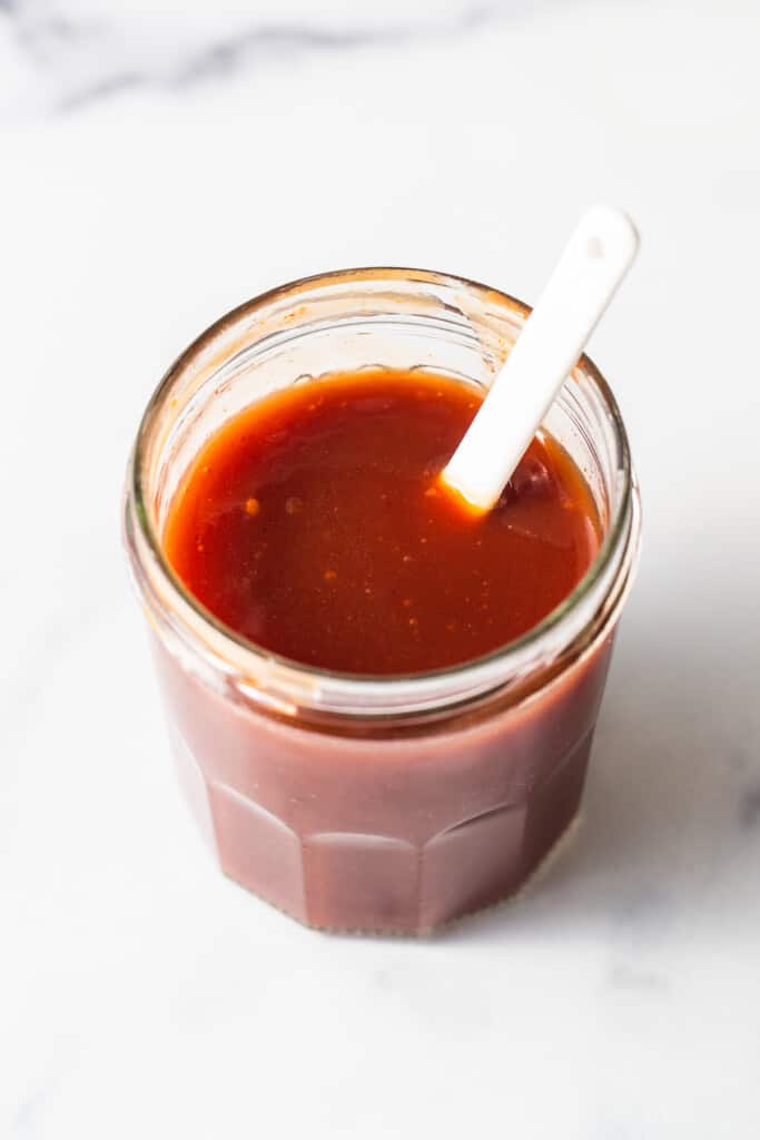 firecracker sauce in a jar with a spoon.