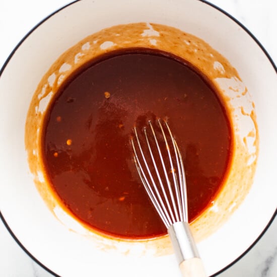 bbq sauce in a bowl with a whisk.