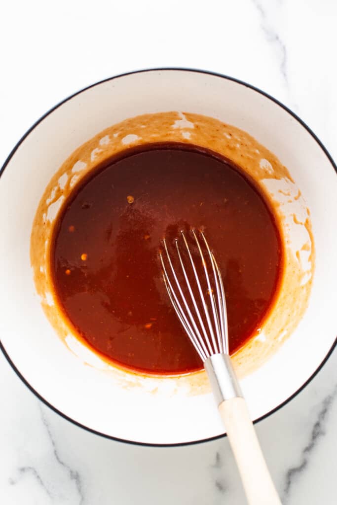 firecracker sauce in a bowl with a whisk.
