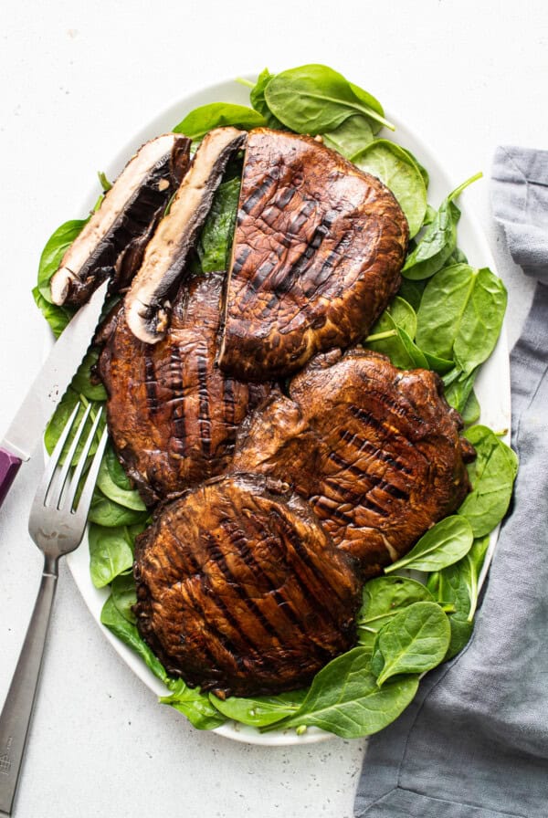 Grilled portobello mushrooms and spinach on a plate.