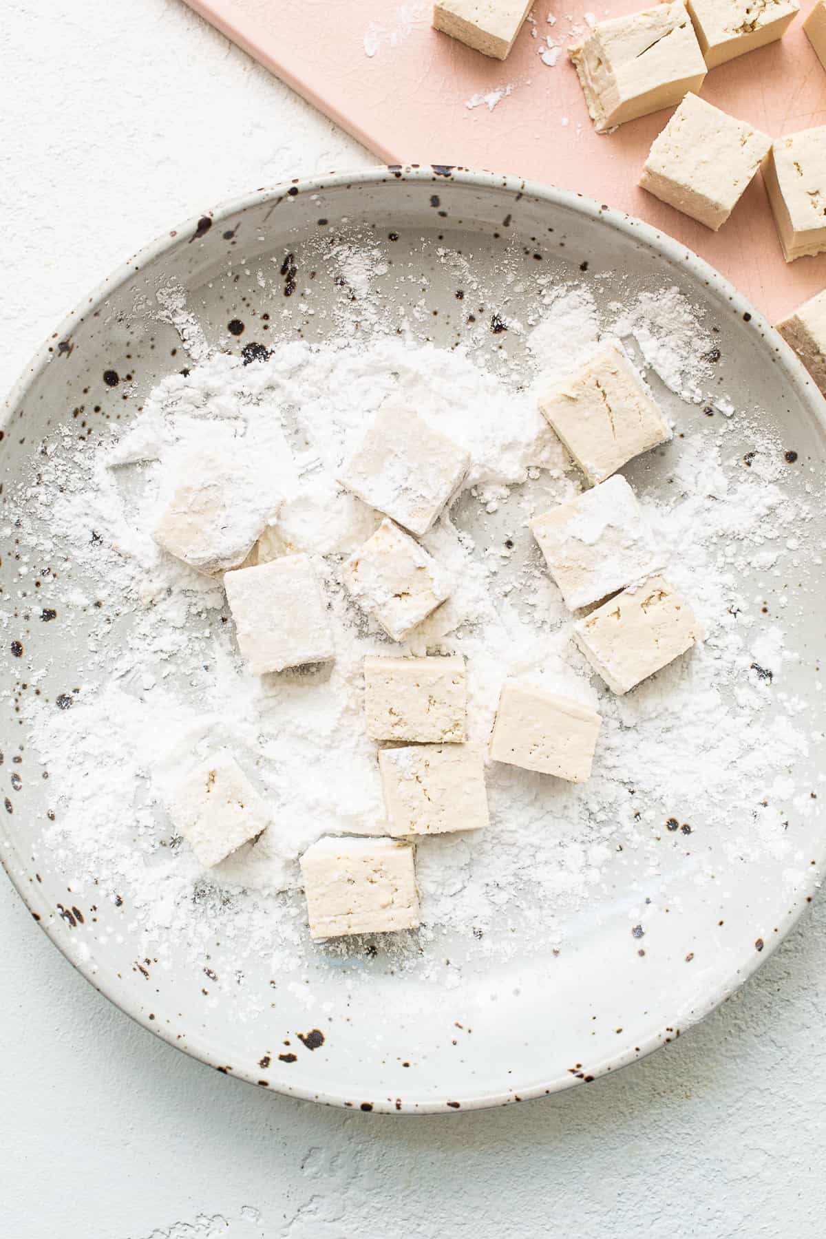 tossing tofu in corn starch.