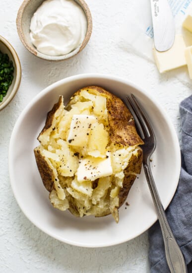 baked potato with butter in bowl.