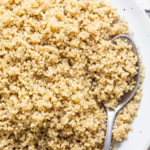Quinoa on a white plate with a spoon.