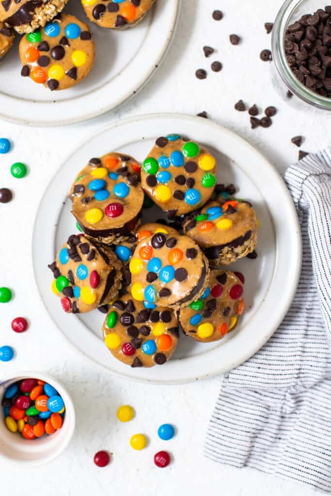 Monster cookie oat cups piled on a plate.