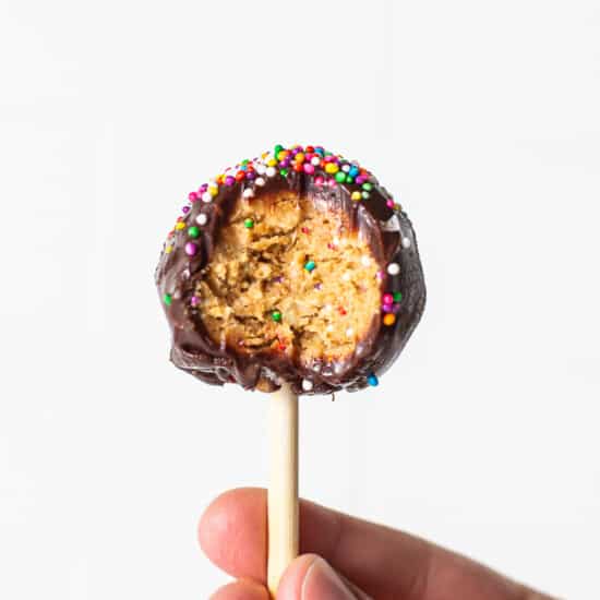 Protein cake pop with a bite taken out of it.