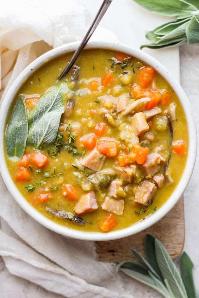 Split pea soup with ham in a bowl with a spoon.