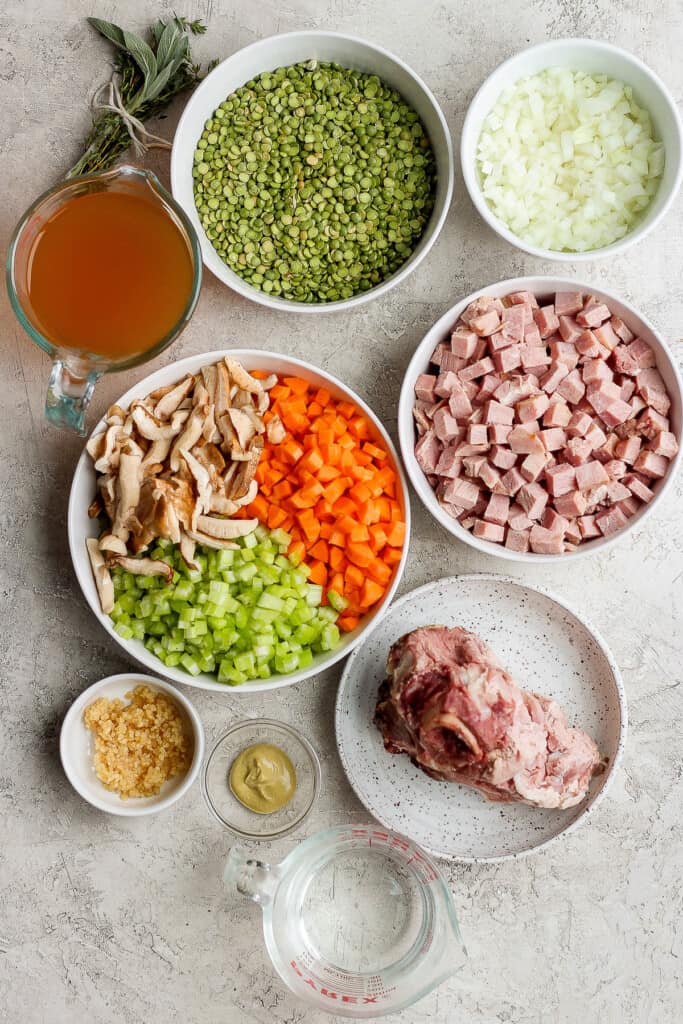 Ingredients for split pea soup with ham in bowls.