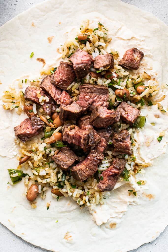Diced steak on a tortilla with rice.