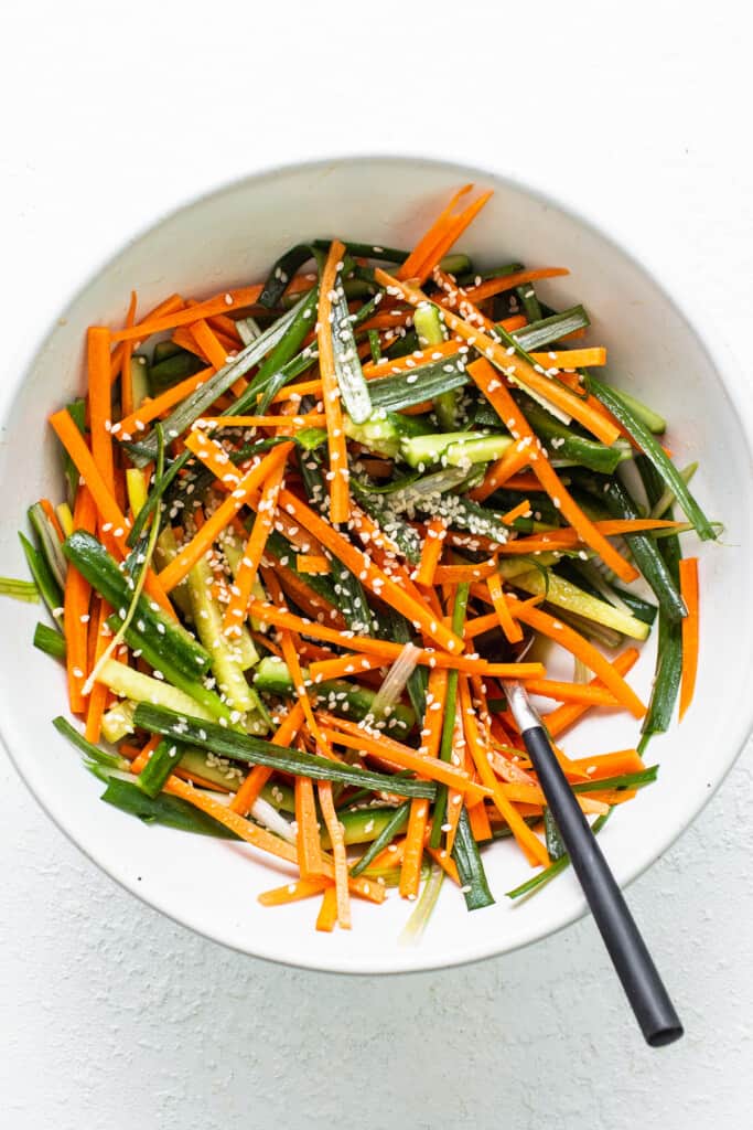 a white bowl filled with carrots and green beans.