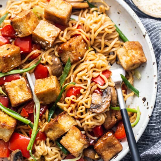 Tofu stir fry in a pan with vegetables and mushrooms.