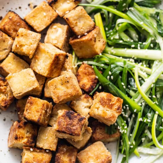 Tofu and greens on a plate.