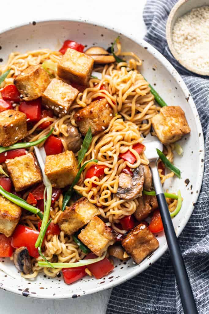 Tofu stir fry in a pan with mushrooms and vegetables.
