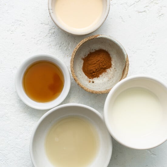 Four bowls with different ingredients on a white background.