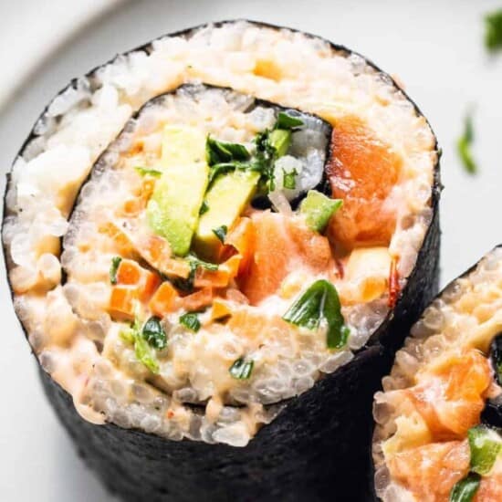 salmon and avocado sushi rolls on a white plate.