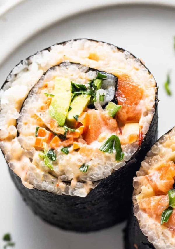 salmon and avocado sushi rolls on a white plate.