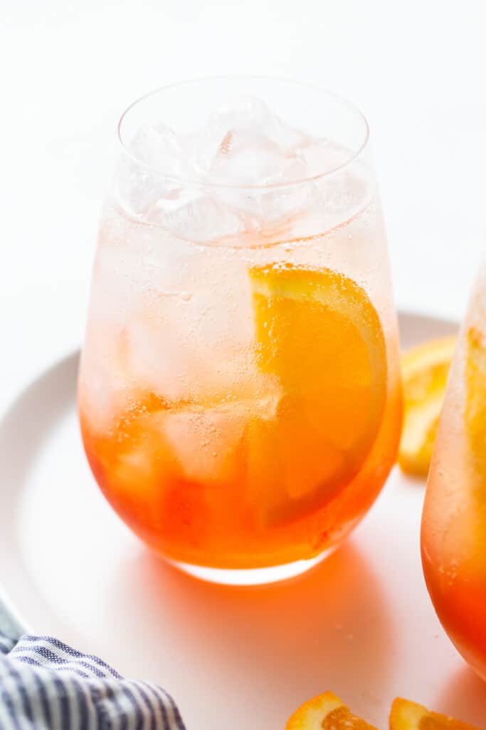 Aperol spritz in a glass with a slice of orange.