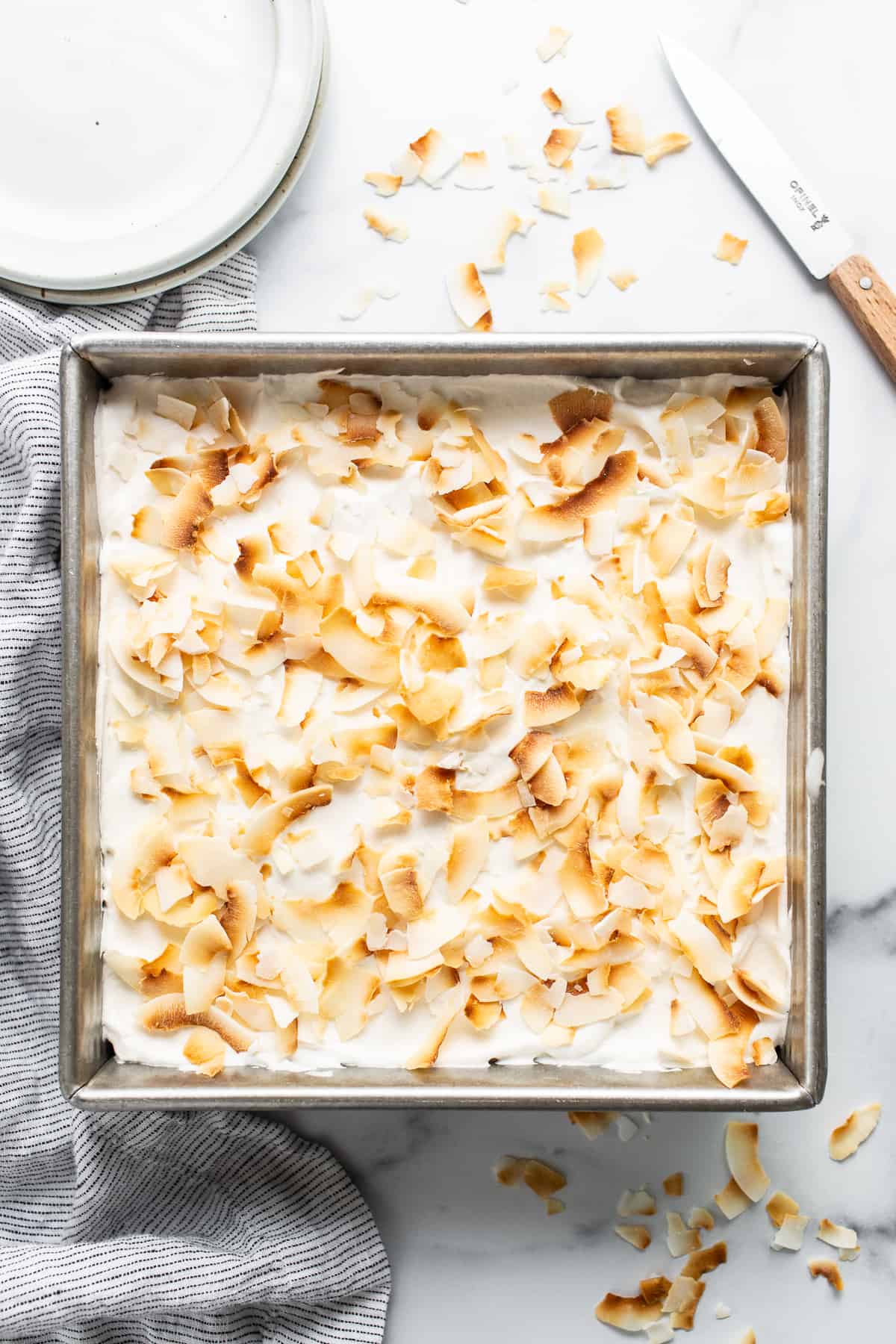 a pan filled with a dessert covered in coconut flakes.